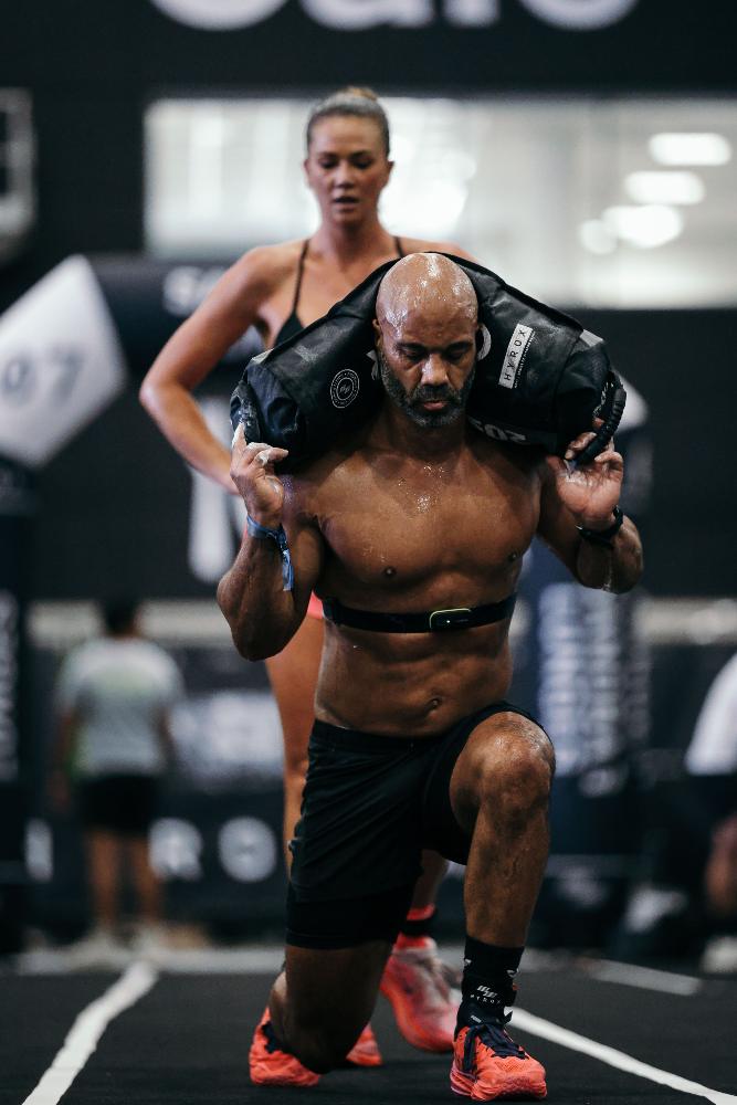 Erin racing a HYROX sandbag lunge