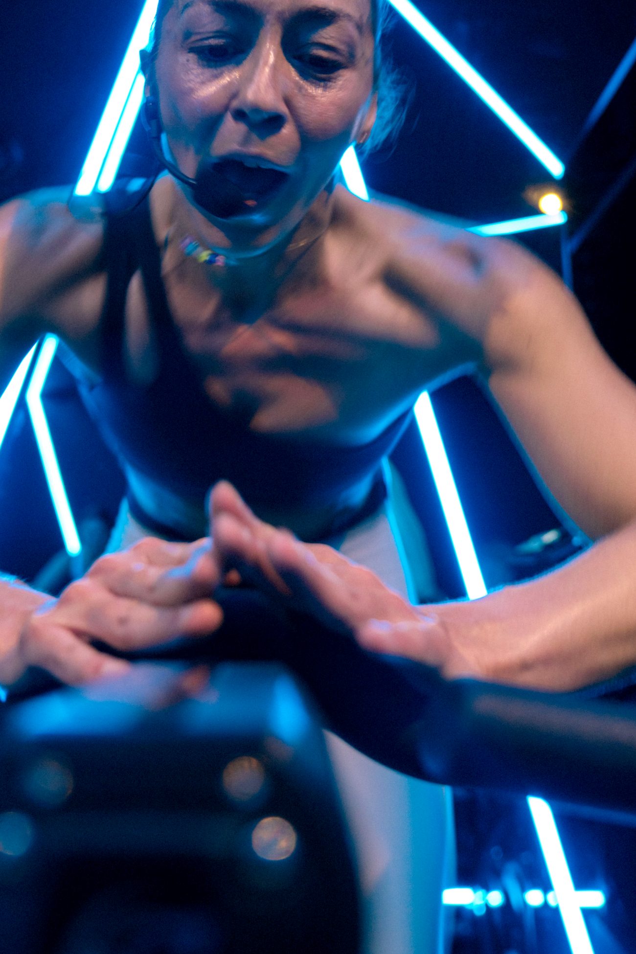 Rider mid-effort on a Stages bike under blue neon in the Soultrain Performance Room, Woolloomooloo