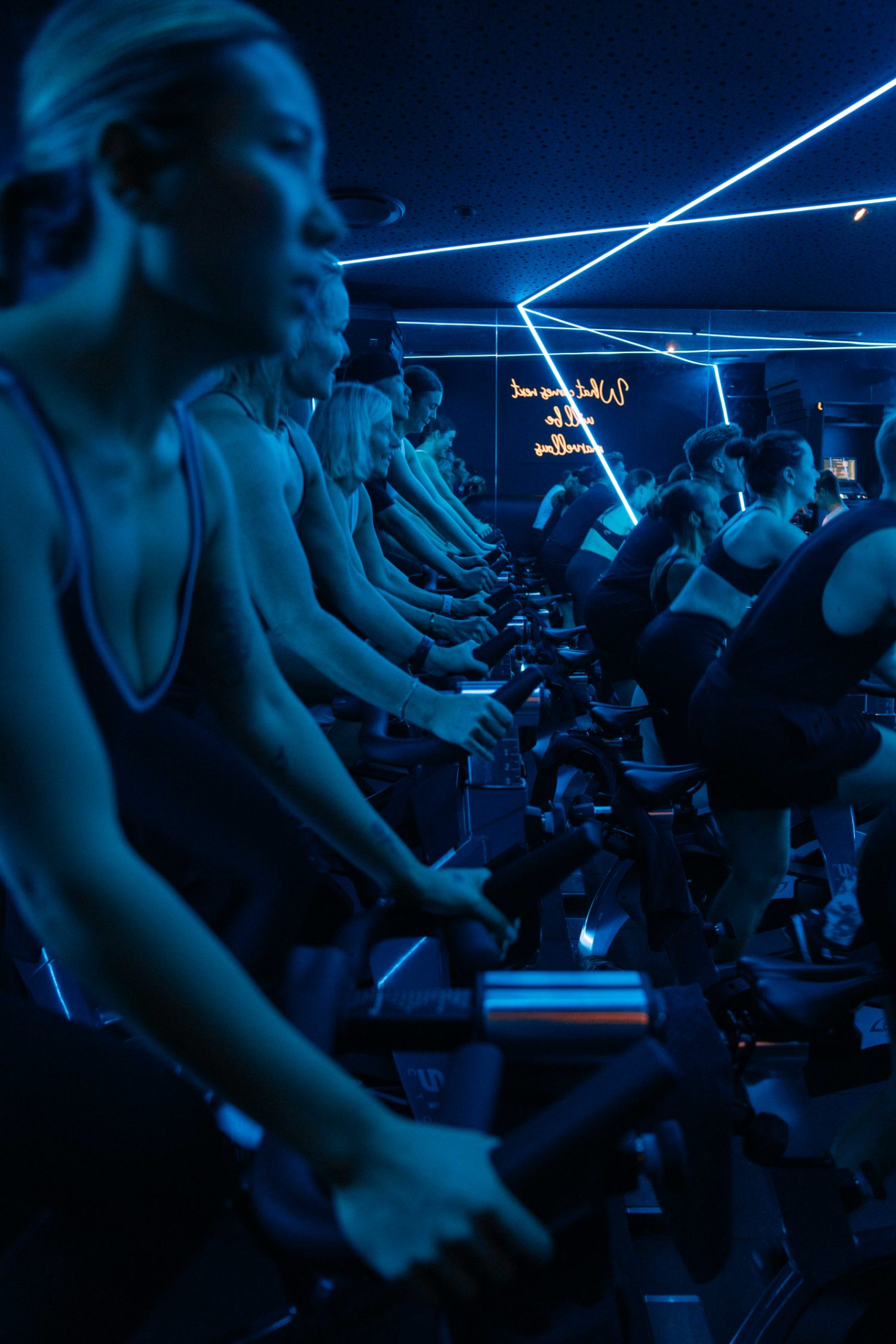 Full Rhythm Ride class lit blue with neon ceiling lines, riders in formation at Soultrain Woolloomooloo