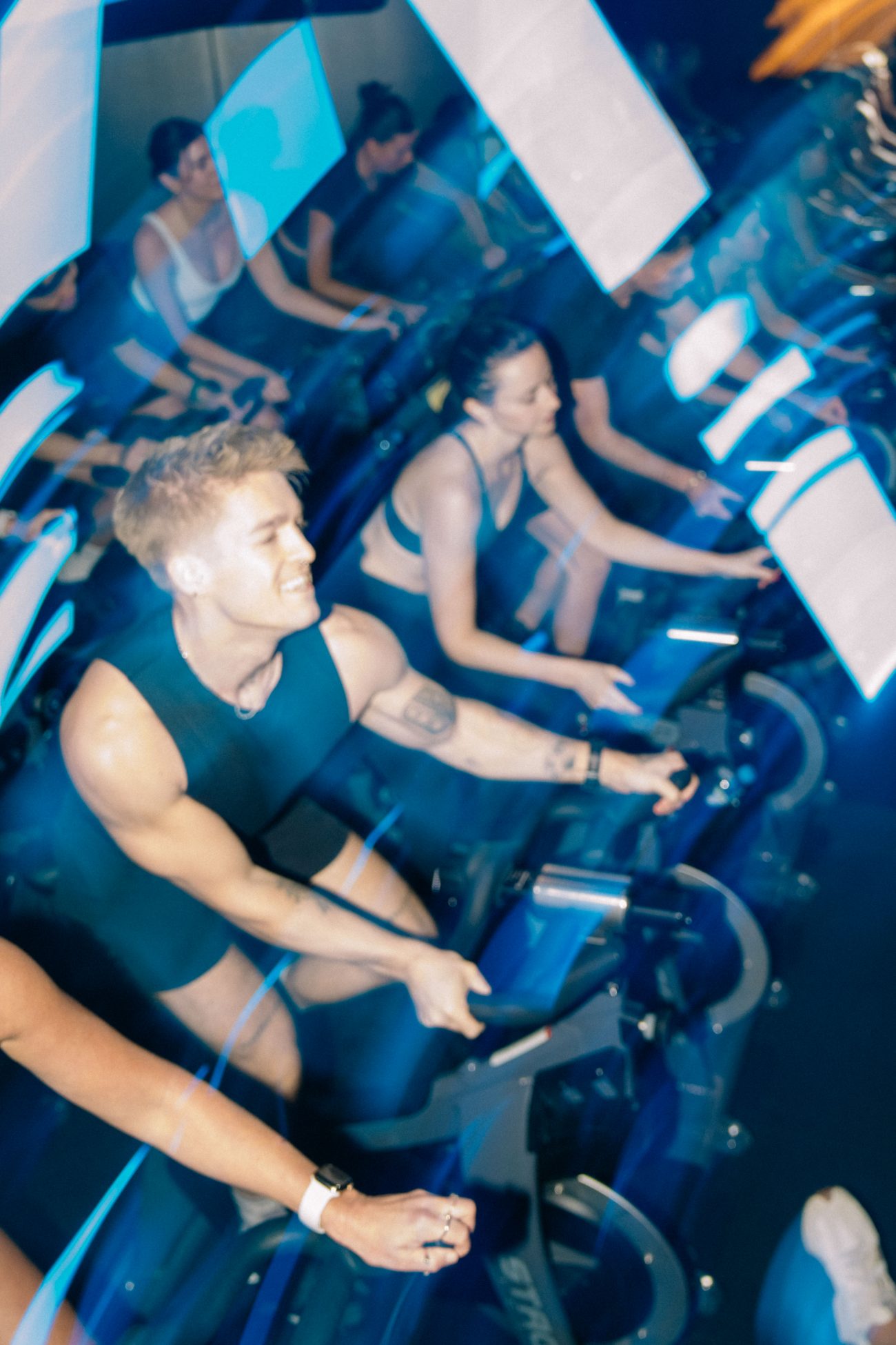 Riders in the dark Rhythm Ride room, lit blue, mid-class at Soultrain Woolloomooloo